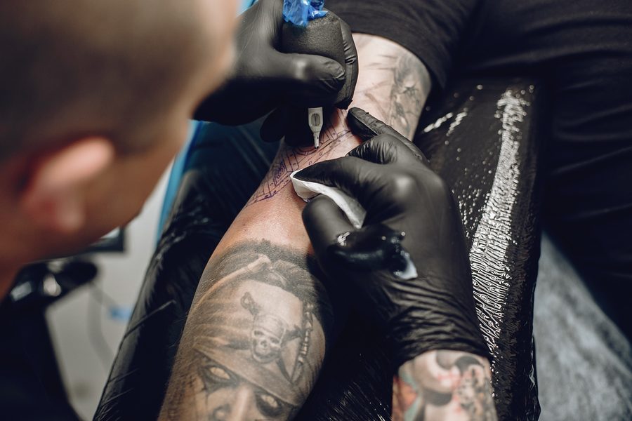 Tatuador trabajando en un brazo